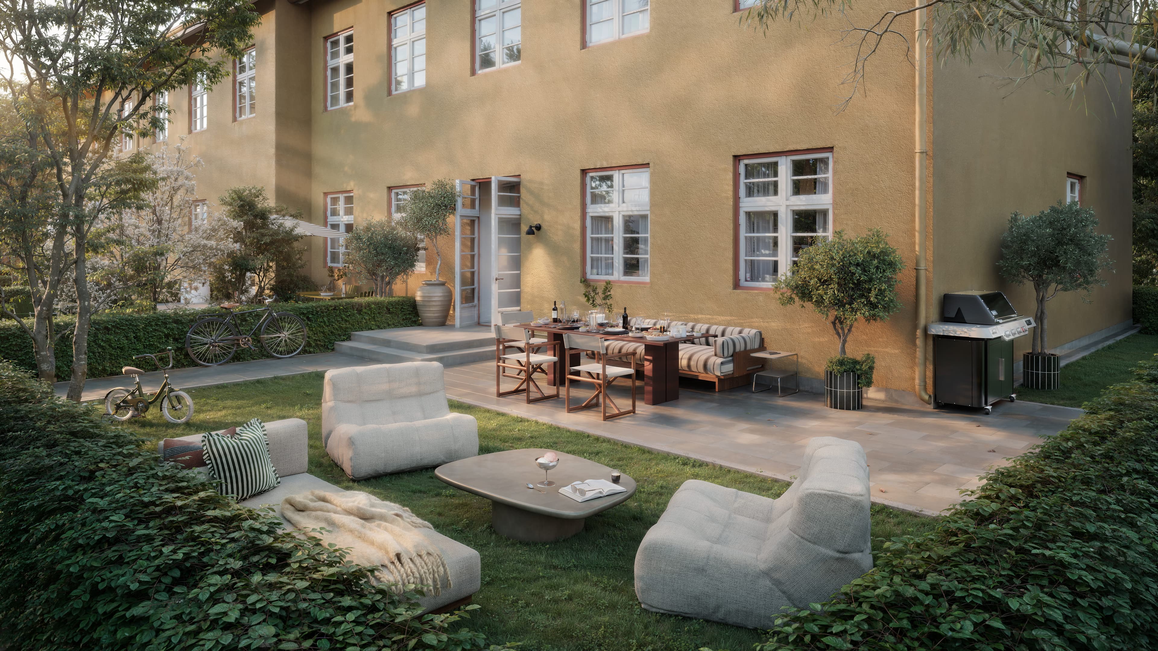 Backyard patio of townhouse with outdoor seating and greenery.